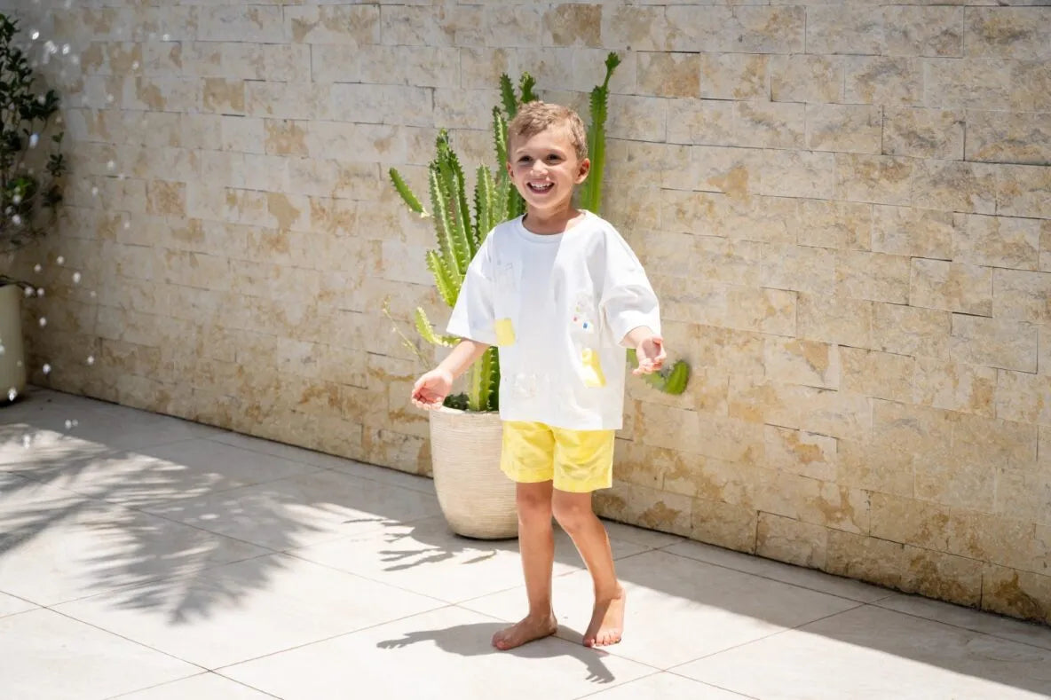 Child in yellow shorts and white top